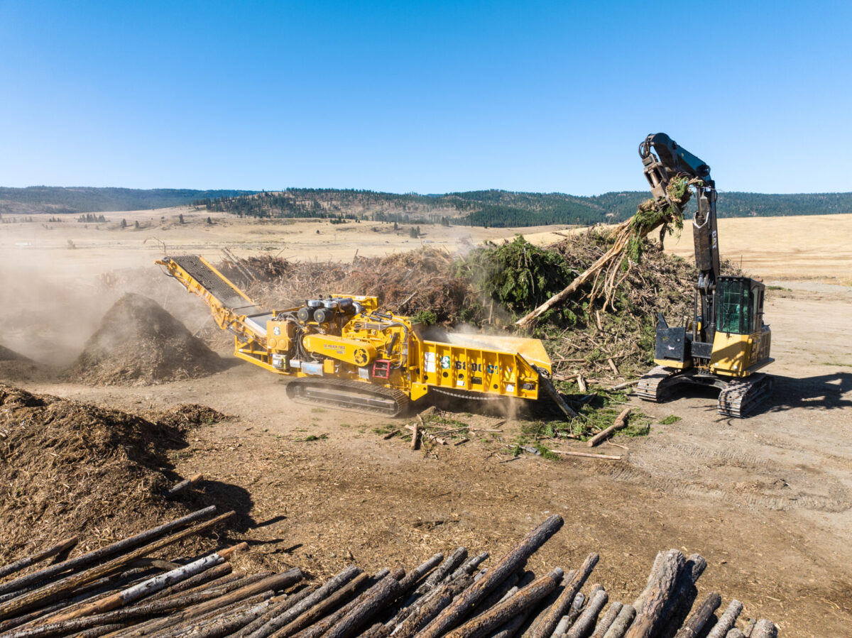 CBI 6800CT horizontal grinder processing tree logs into wood chips and mulch