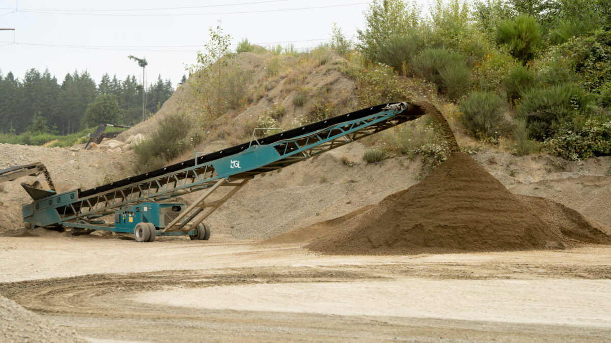 MGL conveyor stacker stockpiling screened sand and gravel material at a quarry site, powered by a portable generator for efficient material handling.