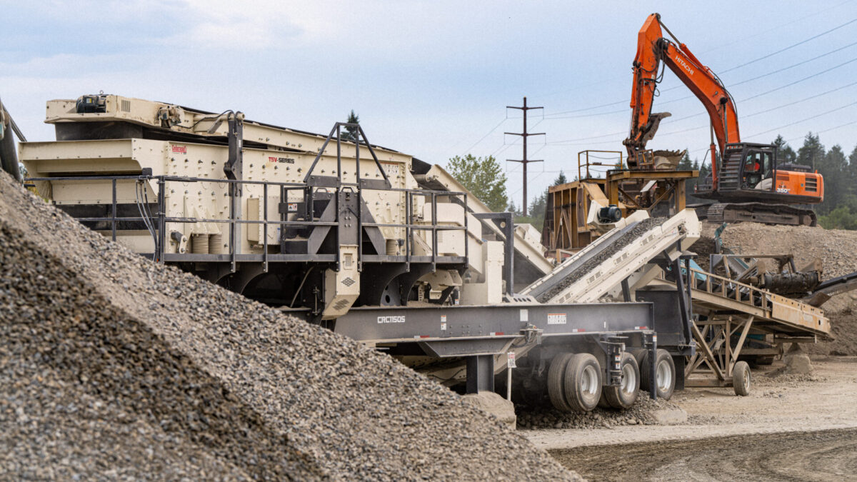 Cedarapids CRC1150S portable cone crusher and TSV Series screen working together in a quarry, loaded by a Hitachi excavator during aggregate production.