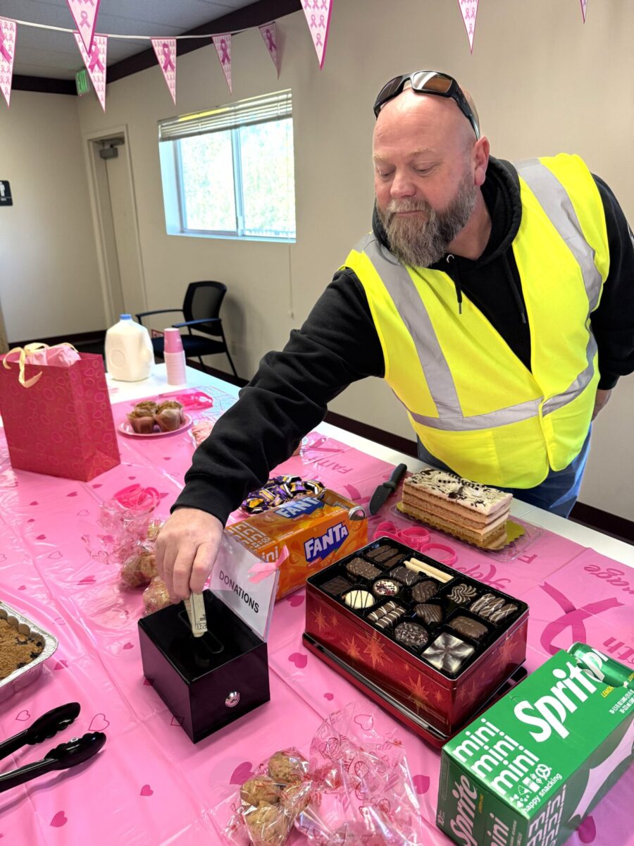 Man in safety hi-vis vest donating money to a bake sale