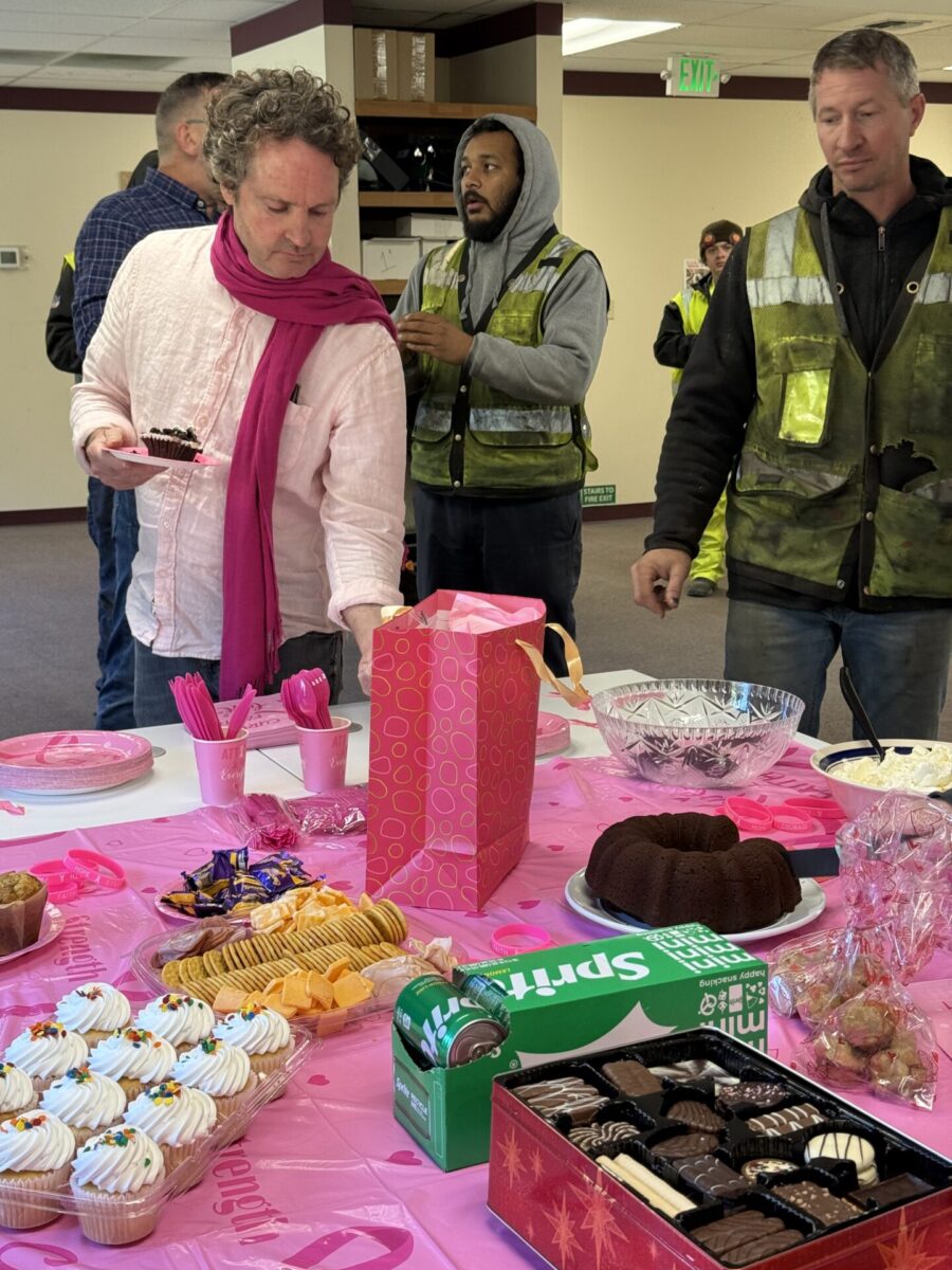 Men participating in a bake sale in an office