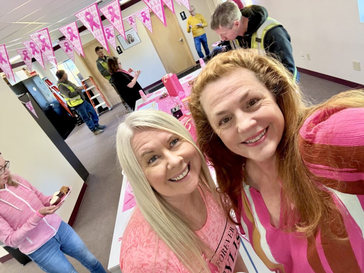 Two women smiling while hosting a bake sale