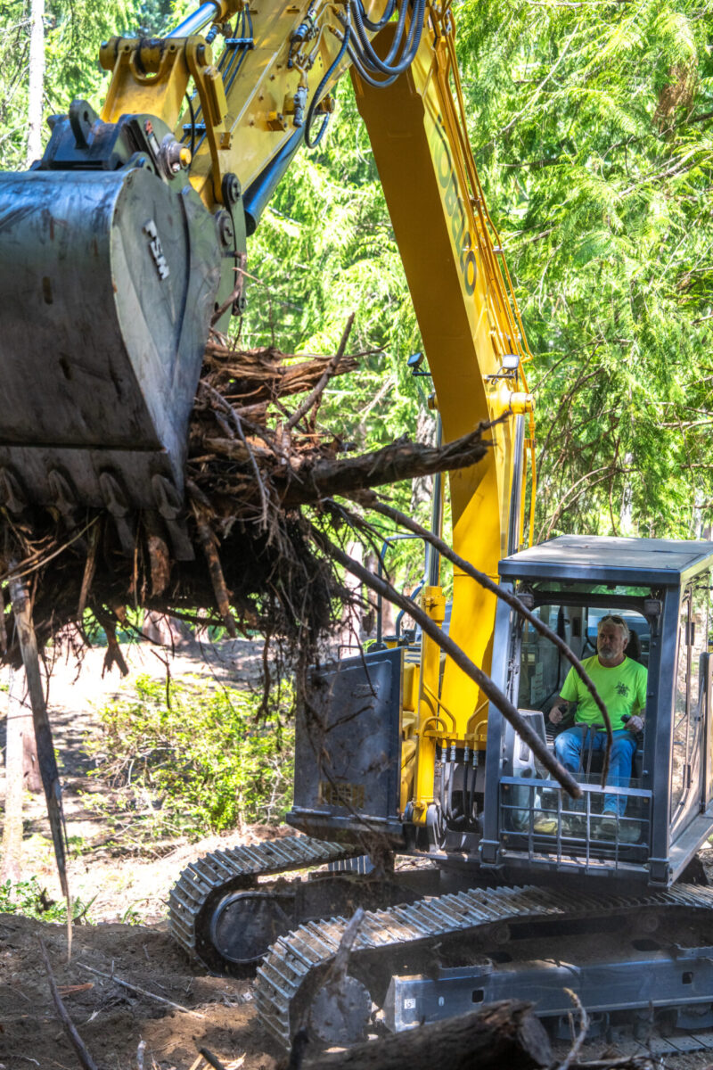 Man inside Kobelco SK170 grappling wood.